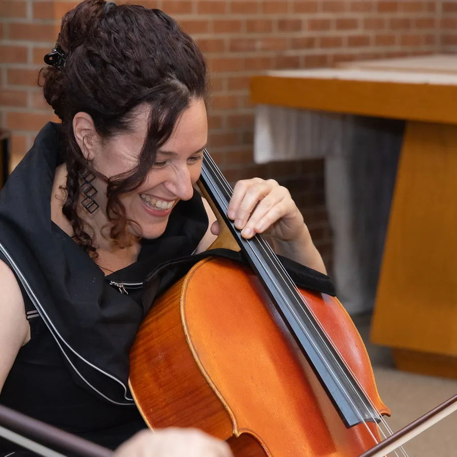 Amy Sue Barston laughing as she plays the cello